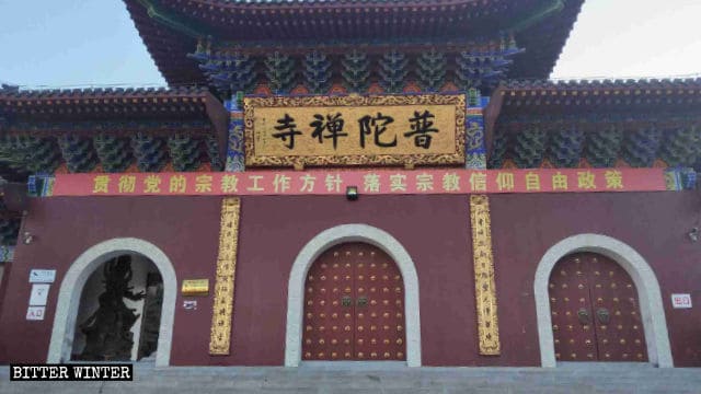 普陀禅寺の前には「信教の自由の政策を実行せよ」と書かれた、中国共産党による皮肉めいたプロパガンダのスローガンが掲示されている。