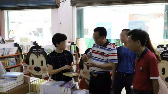 広東省の書店に並ぶ出版物を点検する政府当局。