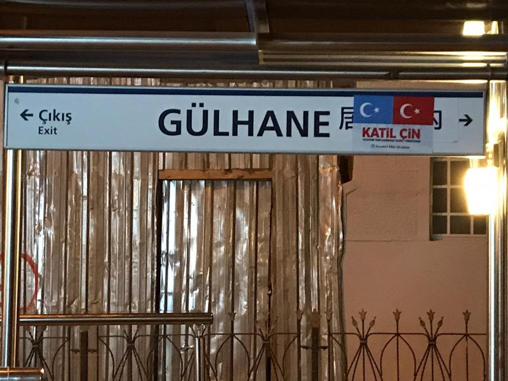 東トルキスタンとトルコの国旗と「殺人者中国」を意味する「カティル・チン(katil çin)」の文字で覆われたギュルハネ路面電車駅の中国語の標識。