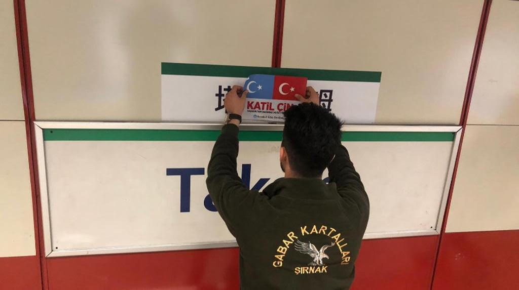 ウイグル族に共鳴するのあるトルコ人が、タクシムにある路面電車の駅に貼られた中国語の標識を東トルキスタンとトルコの国旗と「殺人者中国」を意味する「カティル・チン(katil çin)」というトルコ語の言葉で覆っている。
