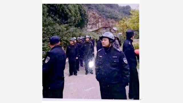 中国共産党の警察が、松山の麓に非常線を張る