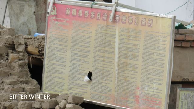 壁の残骸から「宗教に関する新疆ウイグル自治区の規制」というタイトルの掲示板を見ることができる。