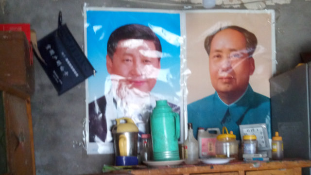 宗教的肖像画の代わりに壁に飾られた毛沢東と習近平の肖像画