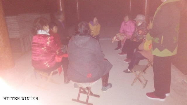 暗がりの中、村の外の展望台に集まる高齢のキリスト教徒たち。