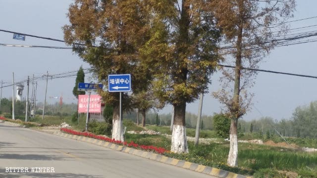 皂樹村の十字路に「訓練施設」と書かれた道路標識が立っている。