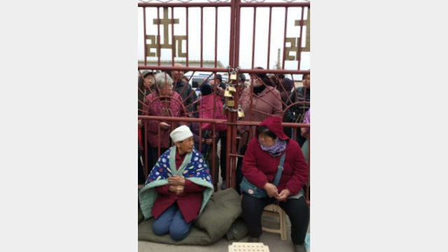 教会員は、中国天主教愛国会が任命した司祭を締め出すために教会の扉を閉ざした。