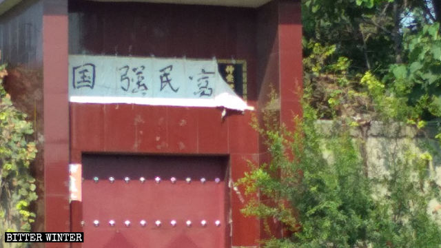 新安県のある住宅の門。宗教的な意味を持つ漢字が、「国強民富（強い国を、人々に繁栄を）」という漢字で覆われた。