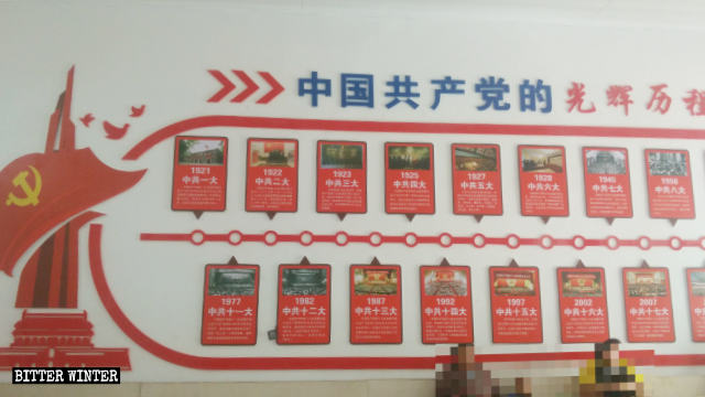 曹呉村の教会の壁に貼られた「共産党の輝かしい歴史」と書かれたポスター。