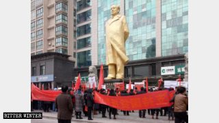 行進する一団が「工人文化苑（労働者文化庭園）」にある大きな毛沢東の銅像の下に集まり、誓いを立てた。