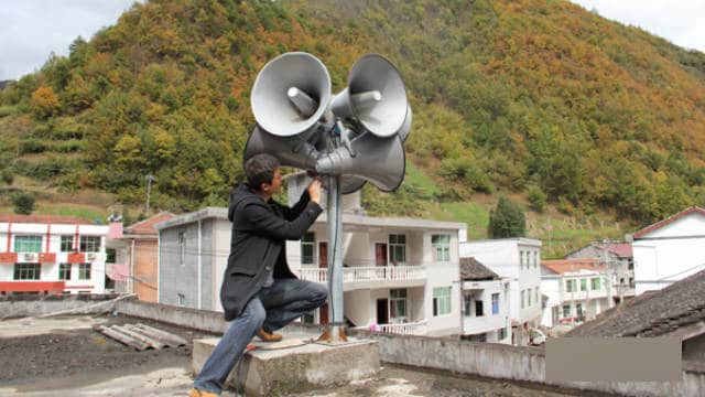 ある労働者が陝西省の鎮坪県で拡声器を設置している様子。