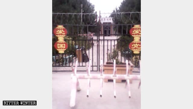 安集海の村のモスクの門には鍵がかけられており、「党を愛する」と「国を愛する」というスローガンが書かれた赤提灯がぶら下げられている。門の前には、車両の車止めが設置されている。