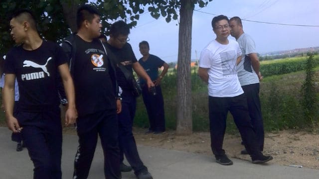 2018年7月18日の朝、孫挙昌さんの家の前に立つ私服警官と政府職員。（提供: 孫挙昌さんのTwitter @qqPHOs3577GXn0N)