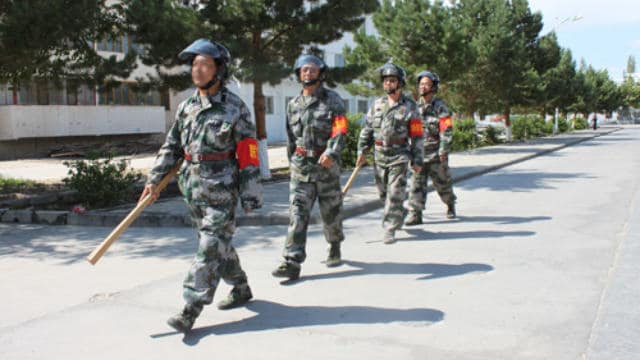 新疆の通りをパトロールする民兵。