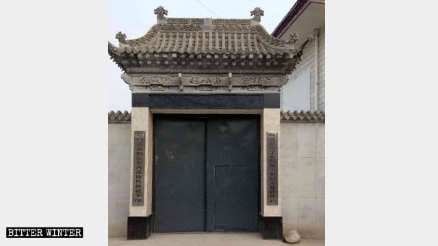 モスクの門は一般的な鉄の門に変えられ、新しい2枚の看板はその建物がもはやモスクではなくなったことを示している。