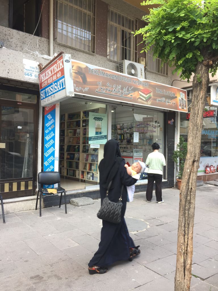 イスタンブールにあるウイグル族の書店の前を通り過ぎるウイグル族の「未亡人」。