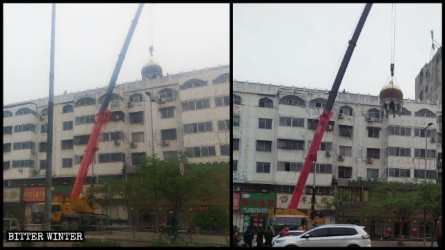 建物の屋根に載った球形のイスラム教の建造物を解体するクレーン車