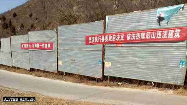 違法建築物の取り壊しに関するプロパガンダのスローガンが后山の奶奶廟に向かう道に掲示されている。