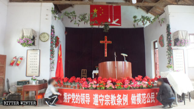 新庄教会堂内部の十字架の上に中国の国旗が吊るされる。