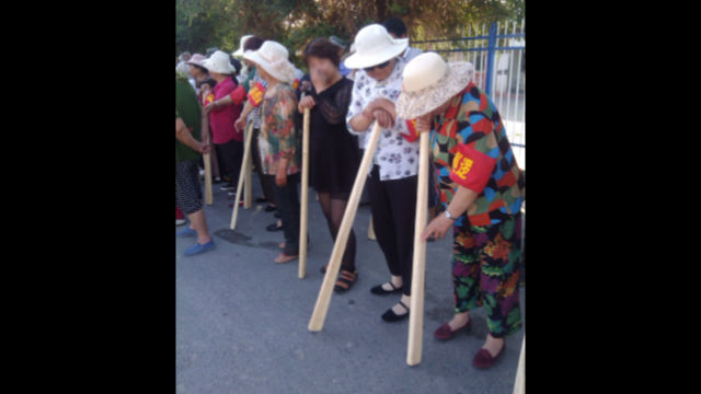 新疆地域の人々は木のこん棒を持って「テロ対策訓練」に参加する。