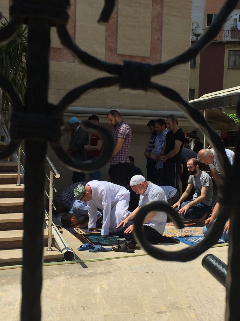 イスタンブール郊外の街、ゼインティンブルヌで金曜礼拝を行うウイグル族の人々。前列左側の男性はウイグル族ならではの刺繍入りのスカルキャップを着用している。この地では自由に祈りを捧げることができるものの、祖国の同胞はモスクに参列することを禁じられ、そして、大勢の人々がそのために勾留されている。