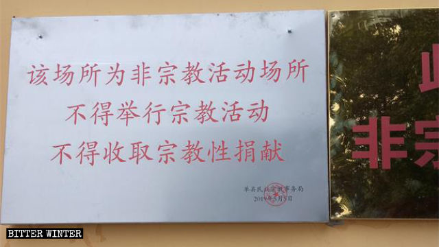 「ここは宗教施設ではない」と記された看板が寺院の東側の壁に掲示された。