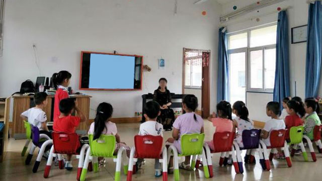 子供たちに話し掛ける幼稚園の教師。