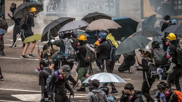 香港の抗議者、報道記者は警察の催涙ガス攻撃に抵抗するため、覆面マスクと傘を必要としている。（Studio Incendo - CC BY 2.0）